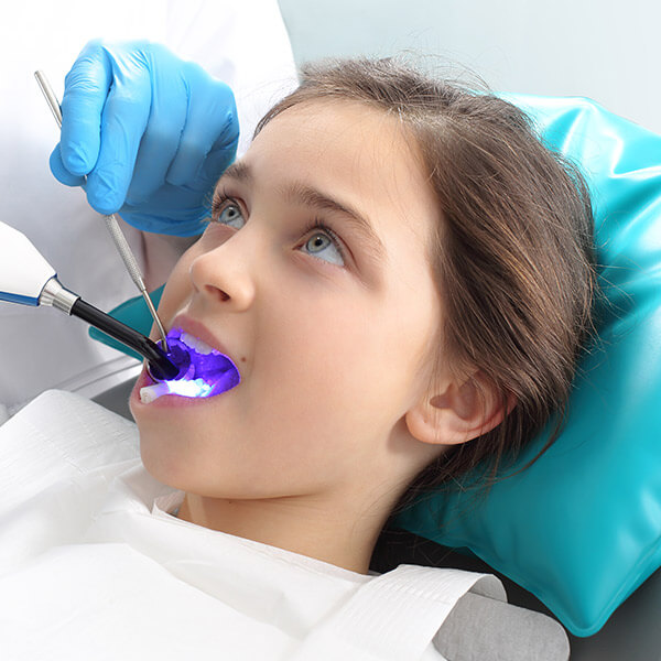 Image of a little girl undergoing a procedure at the dentist